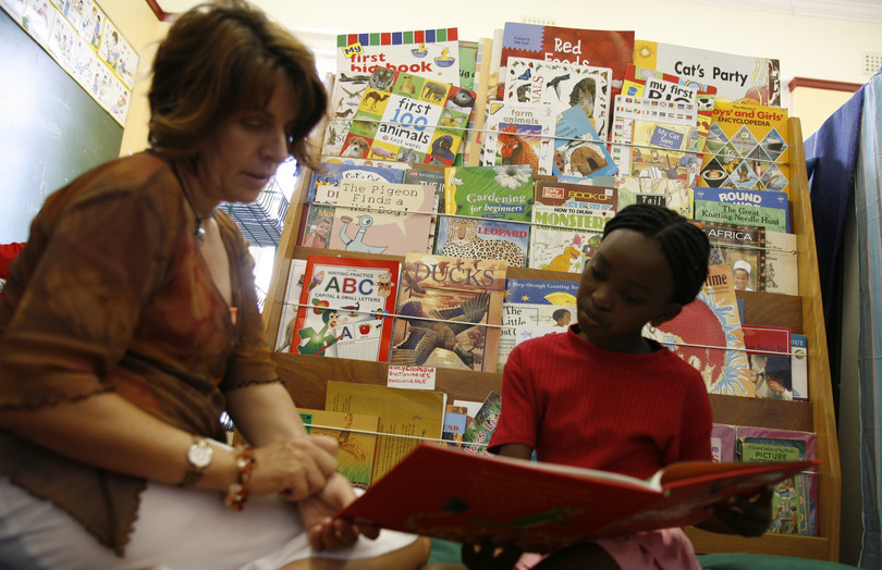 Maurita Weissenberg reads with a small girl